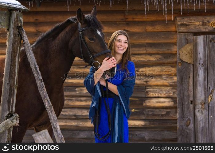 Happy girl hugging a horse and looking into the distance