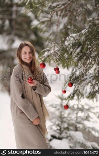 happy girl in christmas days decorates the Christmas tree in the forest. Winter. Happy New Year and Merry Christmas. Christmas decorated interior. The concept of family winter holiday