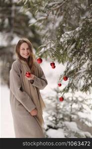 happy girl in christmas days decorates the Christmas tree in the forest. Winter. Happy New Year and Merry Christmas. Christmas decorated interior. The concept of family winter holiday