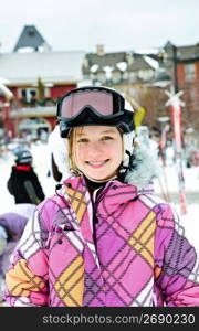 Happy girl in ski helmet at winter resort