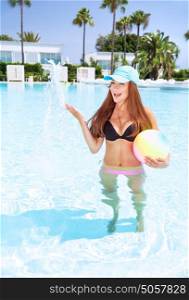 Happy girl in swimming pool playing with ball, anjoy active water game, having fun on beach resort, summer travel and vacation