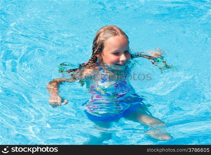Happy girl in the summer outdoor pool.