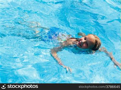 Happy girl in the summer outdoor pool.