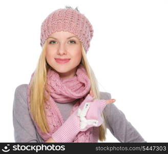 Happy girl in winter clothes pointing on copy space