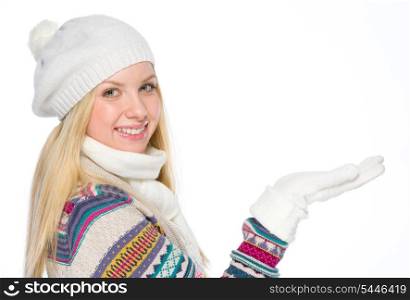 Happy girl in winter clothes presenting something on empty palm