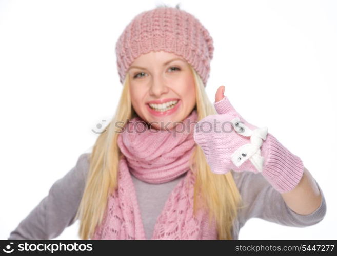 Happy girl in winter clothes showing thumbs up