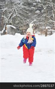 happy girl in winter parka runs on snow