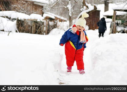 happy girl in winter parka runs on snow