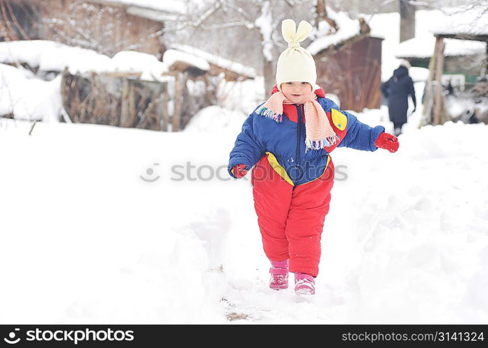 happy girl in winter parka runs on snow