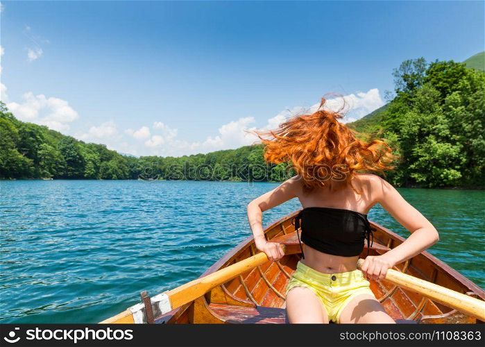Happy girl in wooden boat. Biograd lake, Montenegro, Europe