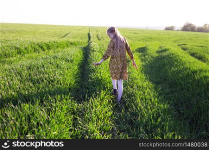 happy girl is joyful walk in the green field. summer and freedom