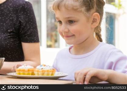 Happy girl is preparing to eat Easter cupcakes