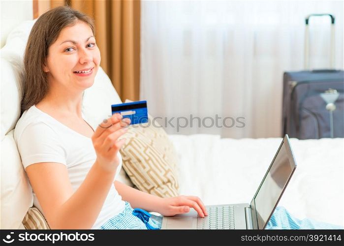 happy girl is preparing to go on holiday with a credit card