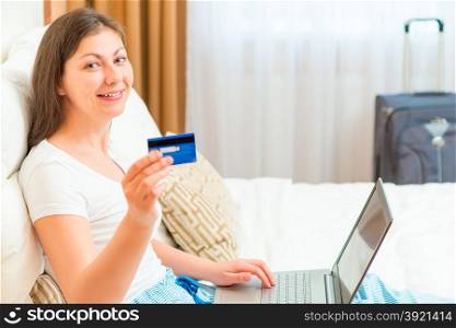 happy girl is preparing to go on holiday with a credit card