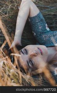 happy girl lies in dry grass. emotions and mood