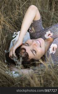 happy girl lies in dry grass. emotions and mood