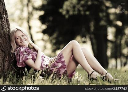 happy girl lying under a tree on a summer day