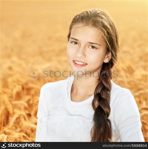 Happy girl on field of wheat with bread