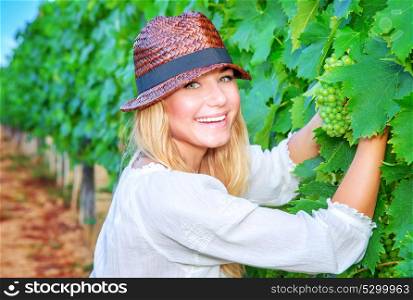 Happy girl on grape field, woman gardener sitting on the ground and picking grapes, organic healthy food, enjoying great harvest, farming and winemaking concept
