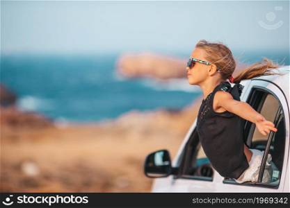 Happy girl on vacation by car at summer day. Family on vacation. Summer holiday and car travel concept