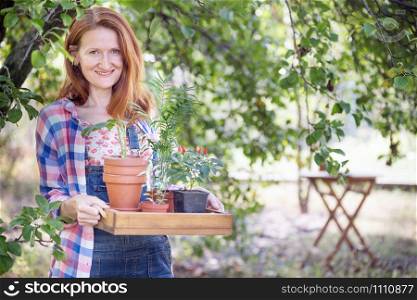 happy girl planting flowers in the garden. flower pots and plants for transplanting