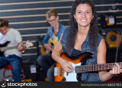 happy girl playing an acoustic guitar in a band