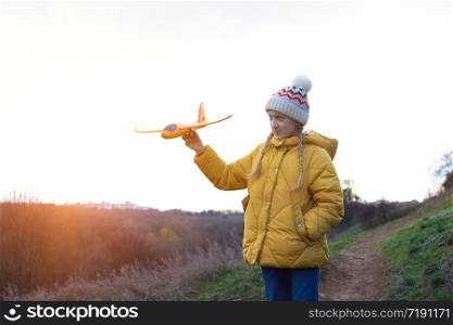 happy girl plays with a toy airplane at the outdoor. fun holidays