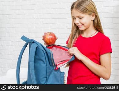 happy girl putting apple backpack
