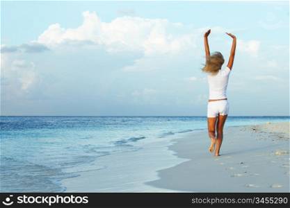 happy girl run along the ocean coast