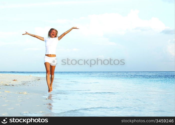 happy girl run along the ocean coast