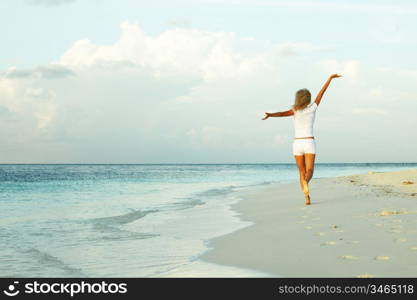 happy girl run along the ocean coast