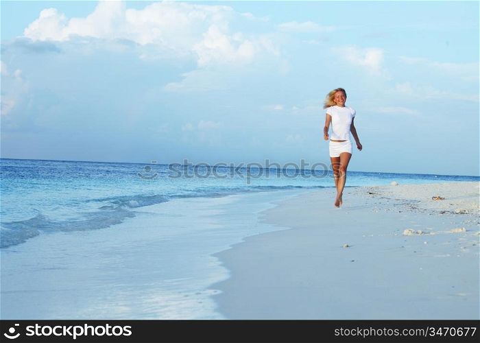 happy girl run along the ocean coast