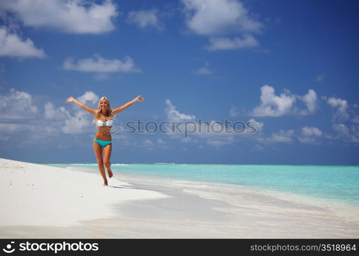 happy girl run along the ocean coast