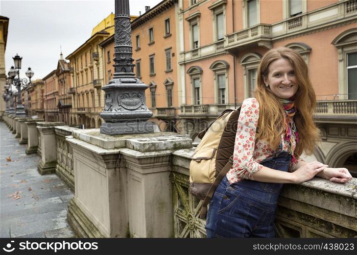 happy girl standing near parapet and looking at the camera, Bologna. italy