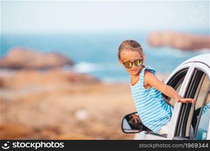 Happy girl travels by car during summer vecation. Family on vacation. Summer holiday and car travel concept