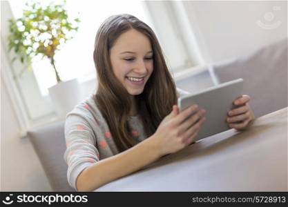Happy girl using digital tablet at home