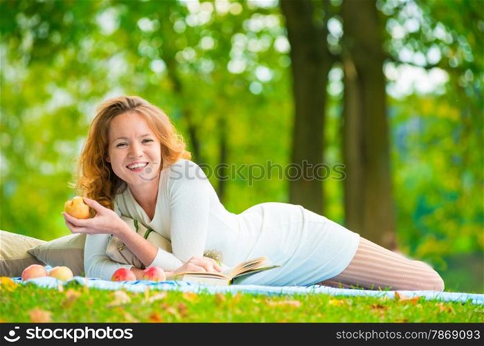 happy girl with a beautiful smile alone in the park having a picnic
