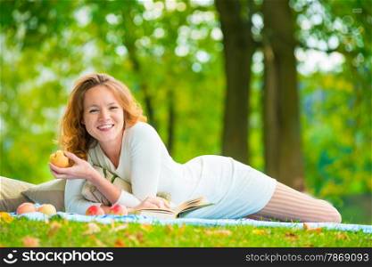 happy girl with a beautiful smile alone in the park having a picnic