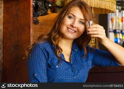Happy girl with alcohol glass in night club at counter.. Girl with alcohol glass in pub club