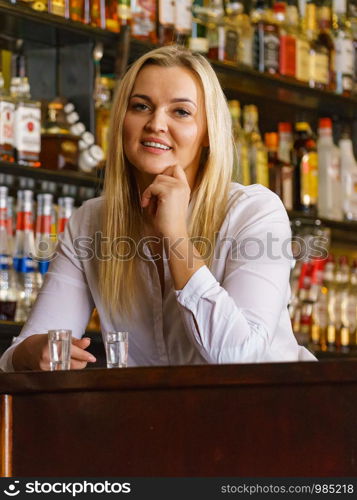 Happy girl with alcohol glass in night club at counter.. Girl with alcohol glass in pub club