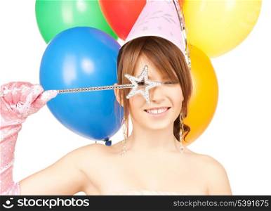 happy girl with colorful balloons in party cap and magic stick