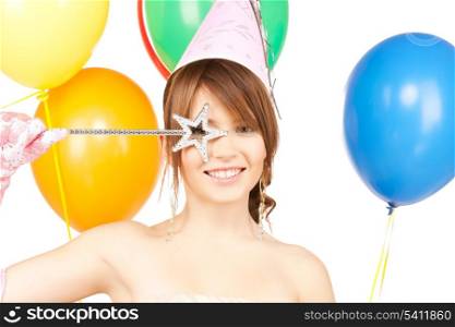 happy girl with colorful balloons in party cap and magic stick