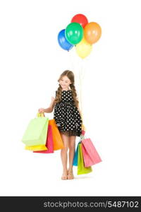 happy girl with shopping bags and balloons over white