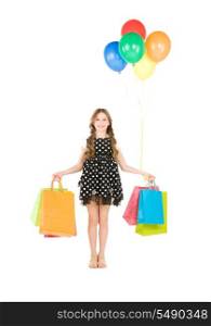 happy girl with shopping bags and balloons over white