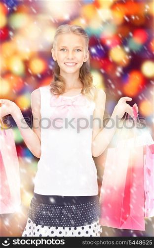 happy girl with shopping bags over christmas lights