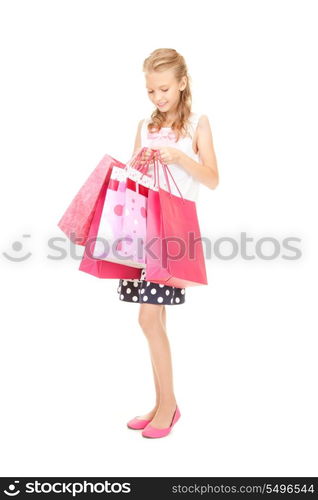 happy girl with shopping bags over white