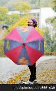 happy girl with umbrella outdoor in park on autumn season rain day