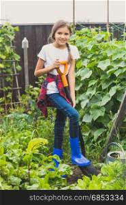 Happy girl working at garden with shovel