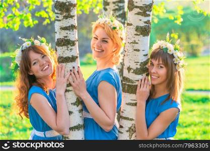 happy girlfriends in a wreath of flowers in the park