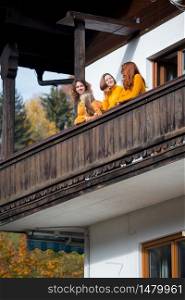 happy girls on a balcony in a mountain chalet. family travels